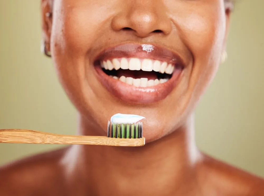 Smiling Woman With White Teeth Holding A Toothbrush