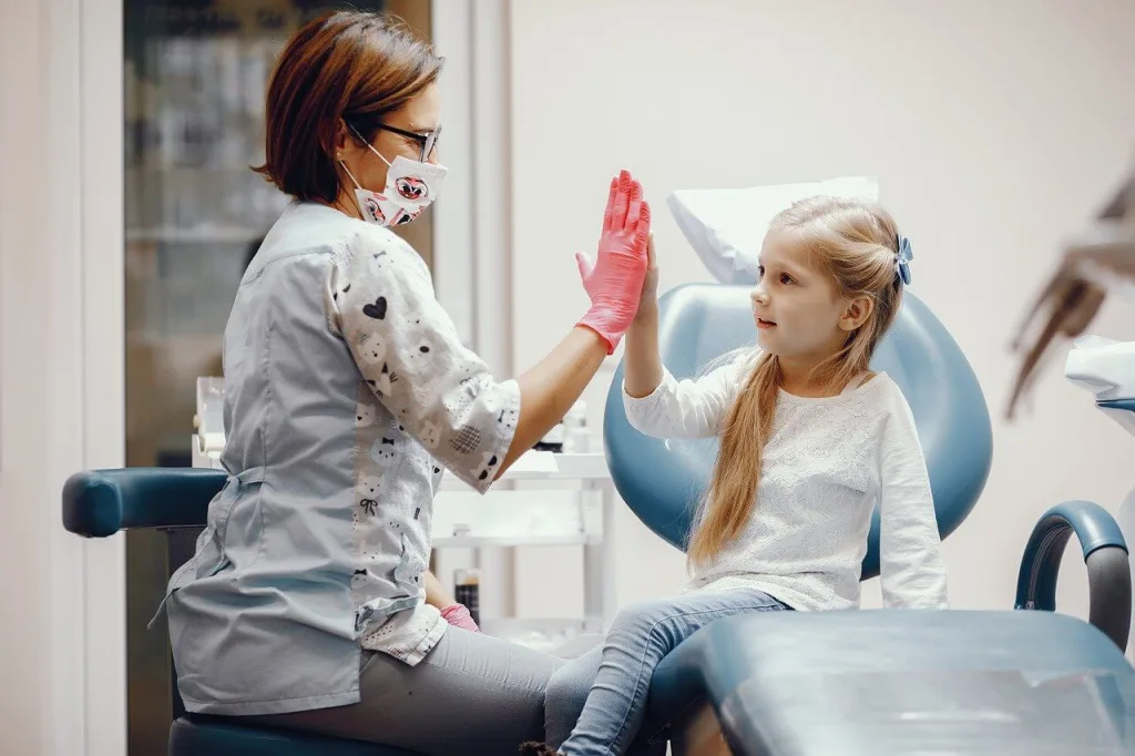 Pediatric dentist cheering a girl