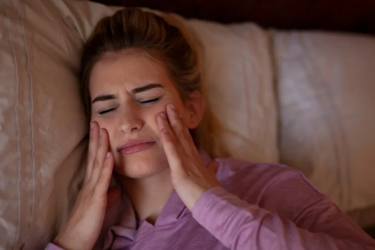 Woman holding her cheeks in the morning after biting her tongue while sleeping