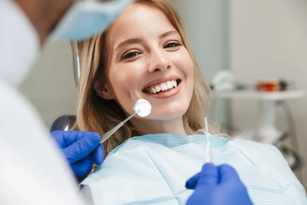 satisfied young woman sitting on dental chair in medical center