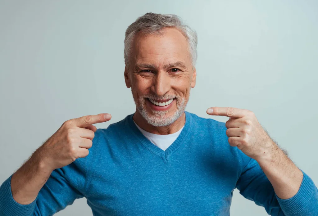 Senior man with white teeth isolated on grey background